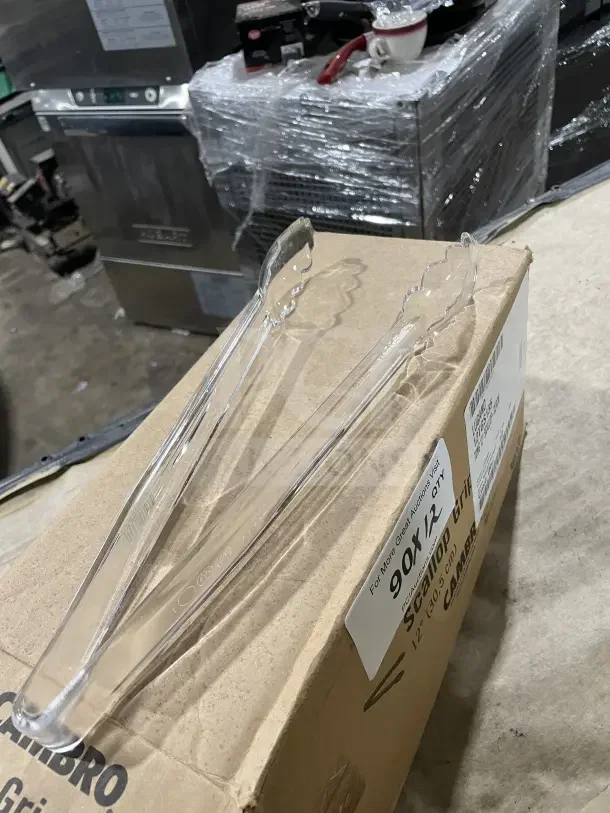Cambro Lugano 12" clear polycarbonate scallop grip tongs on box. New condition. Box labeled "90PC12 Scallop Tongs."