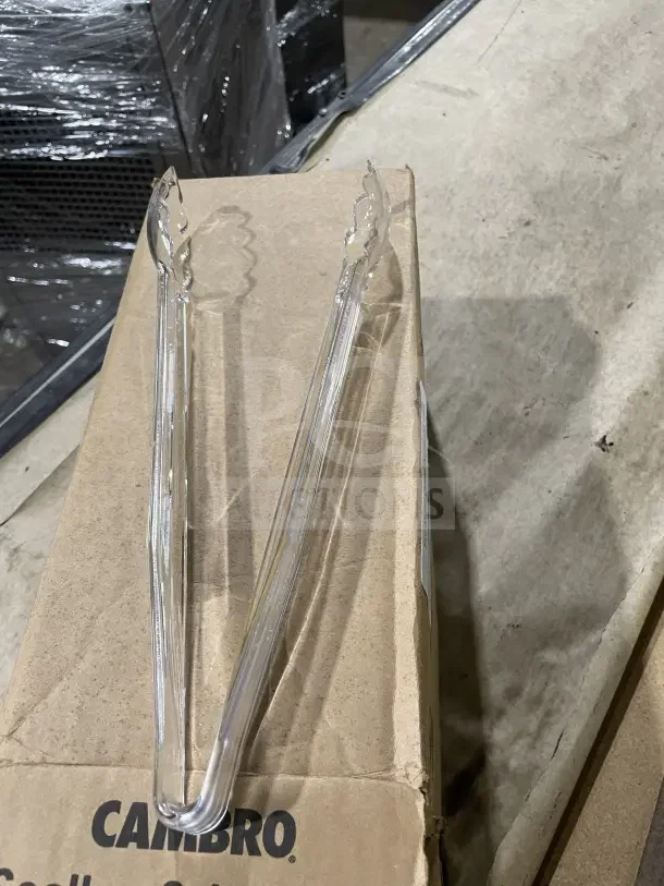 Clear Cambro Lugano 12" polycarbonate scallop grip tongs on cardboard box, in good condition, with logo visible.