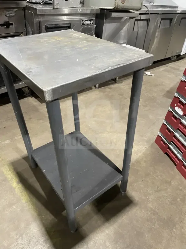 Commercial stainless steel equipment stand with lower shelf, sturdy legs, and used condition, ideal for kitchen use.