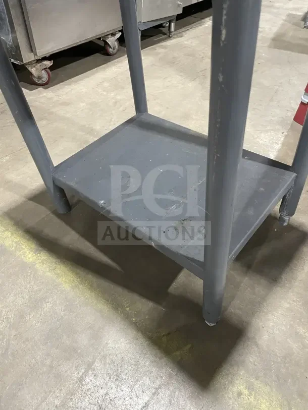 Commercial stainless steel equipment stand on legs, used condition, sturdy construction, visible surface wear.