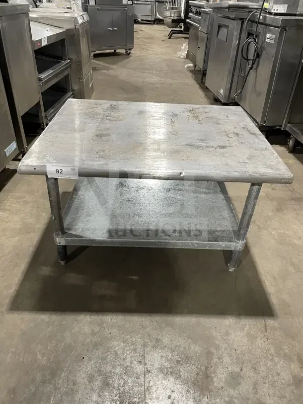 L&J Commercial stainless steel two-compartment equipment stand on legs. Used condition with visible wear, auction tag "92".