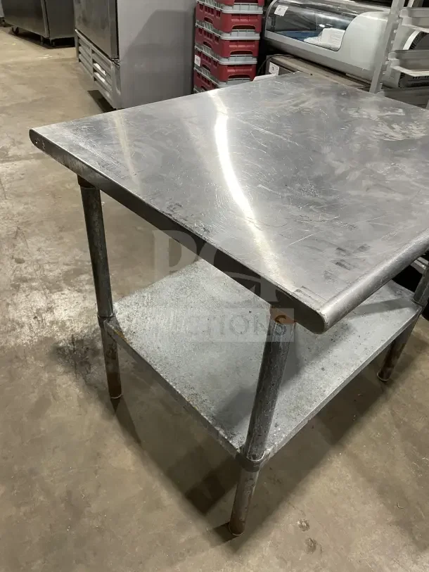 Commercial stainless steel equipment stand with two compartments, on sturdy legs. Features a durable, polished surface.