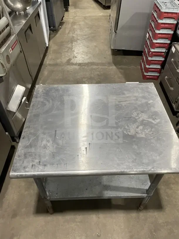 Commercial stainless steel 2 compartment equipment stand on legs, showing surface wear, ideal for kitchens or restaurants.