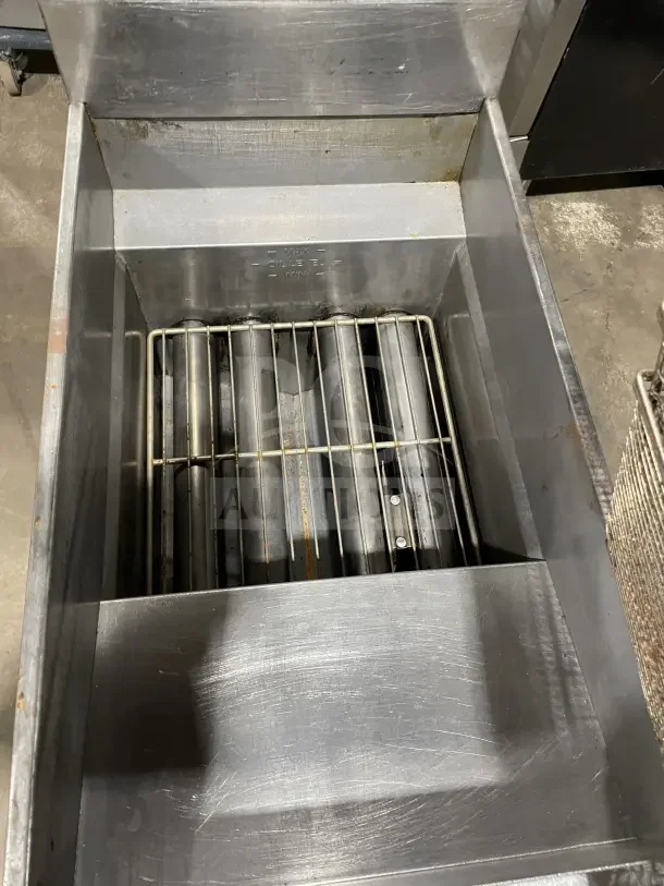 Pitco SFSG14 JS natural gas fryer, 40 lb. capacity, stainless steel, with backsplash, basket hanger, on legs, visible wear.
