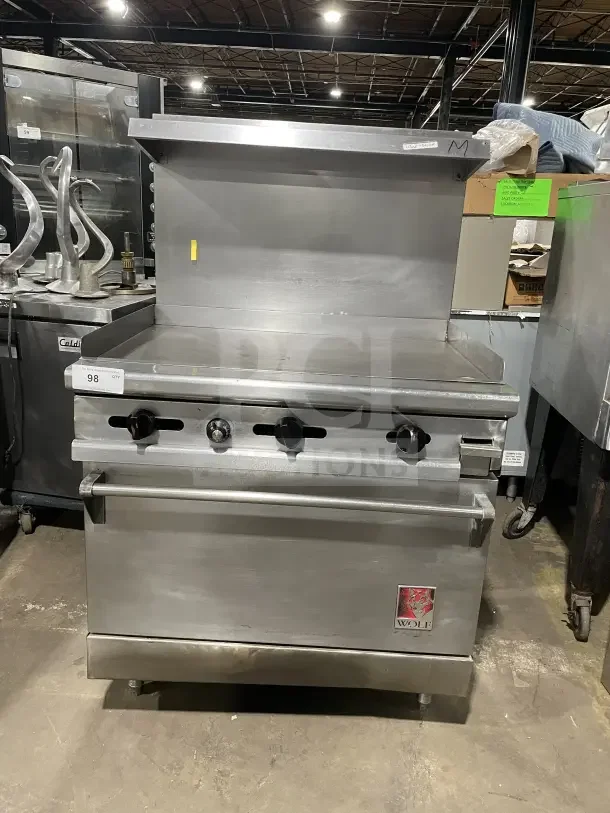 Wolf commercial stainless steel gas stove, 4 burners, with back and sides, on casters. Excellent condition, prominent logo.
