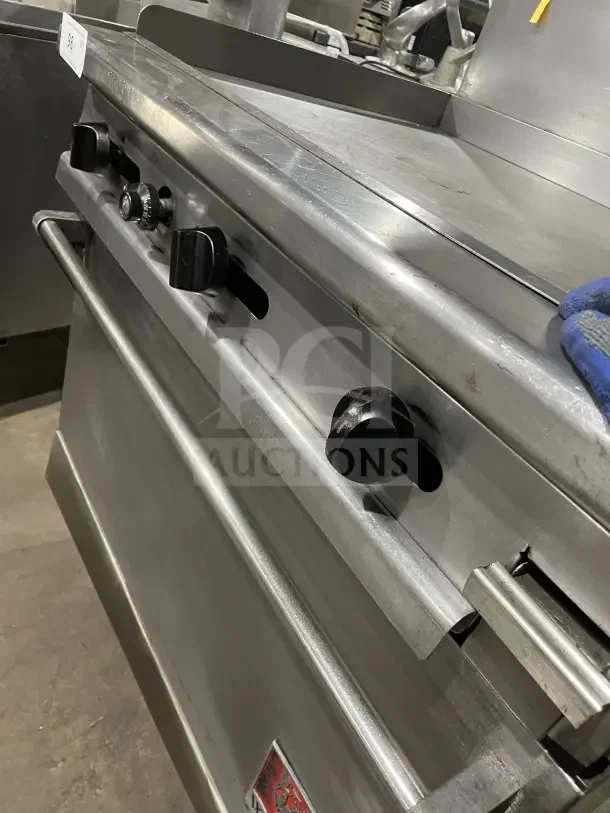 Wolf commercial stainless steel gas range with 4 burners, back and side splash, on casters. Used condition.