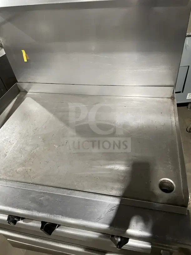 Wolf commercial stainless steel gas stove with 4 burners, back and sides, on casters. Rugged condition, ideal for kitchens.