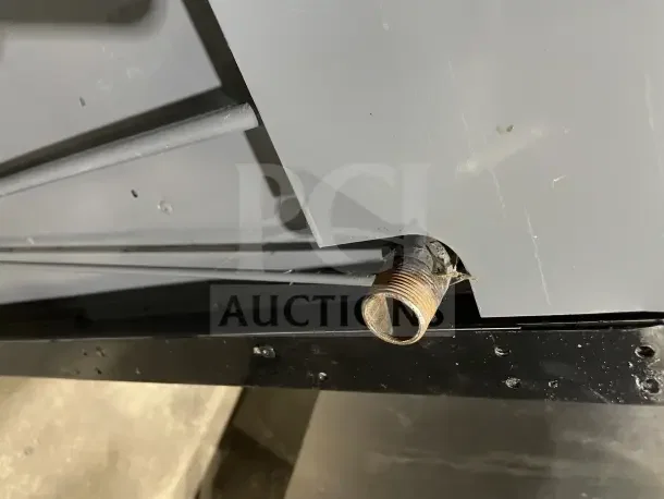 Wolf commercial gas stove, stainless steel, 4 burners, with back and sides, on casters, shown from underside.