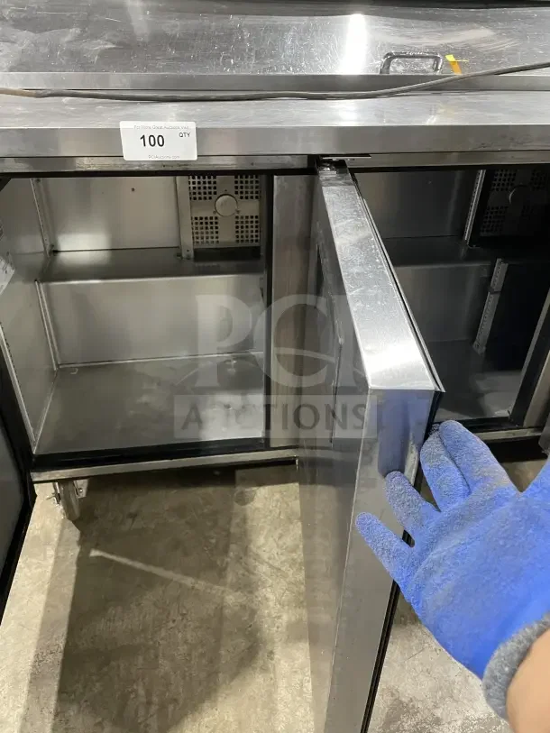 True SSU-72-08 S 3 Door Refrigerated Prep Table. Stainless steel, 72", dual door open. Model: SSU7208 S. 115V. Auction tag: PCIAuctions.