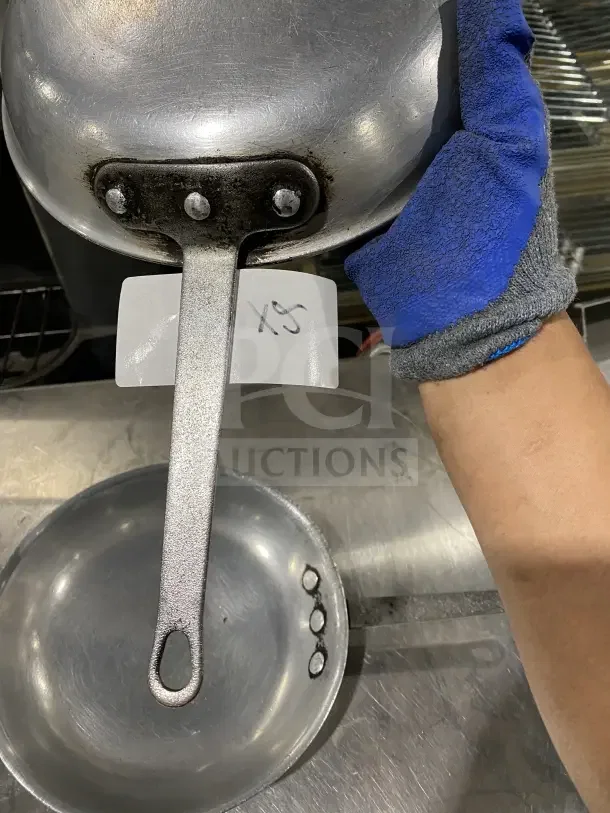 Commercial aluminum non-stick fry pans with handles, showing underside and attached tag marked "XS," includes 2 pans.