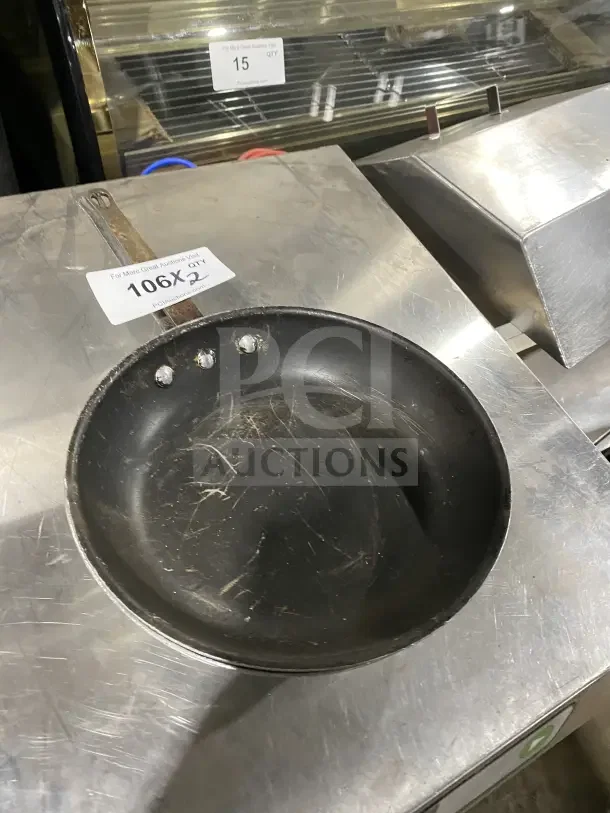 Commercial aluminum non-stick fry pan, slightly worn, includes handle. Auction tag reads "106X, 2X Your Bid."