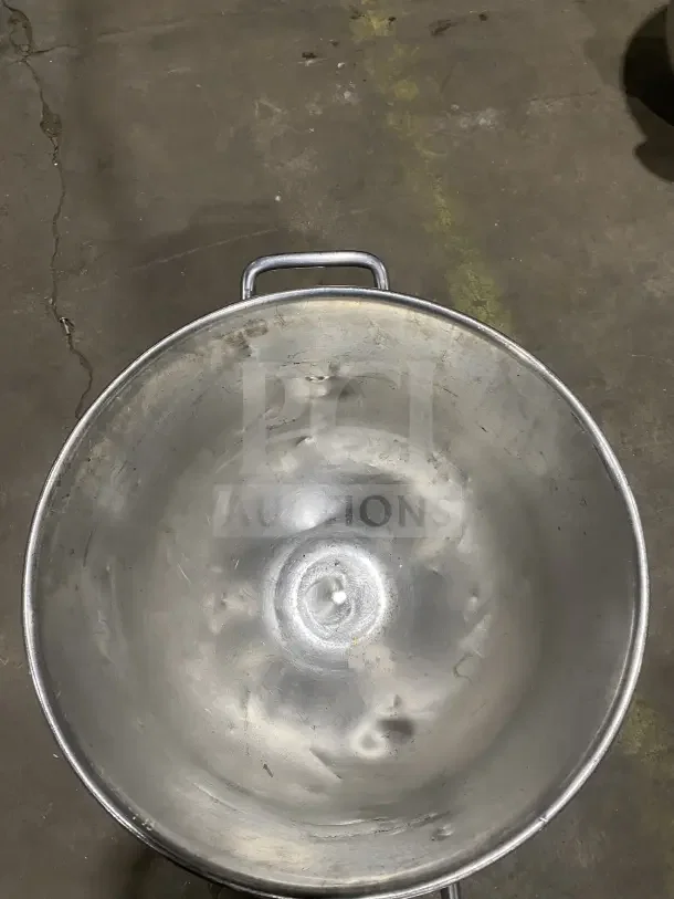 Commercial stainless steel mixing bowl with handles. Slightly worn; ideal for heavy-duty use.