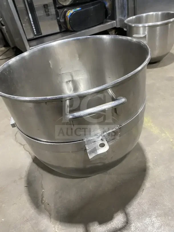 Commercial stainless steel mixing bowl with handles, durable design, minor scratches, ideal for heavy-duty kitchen use.