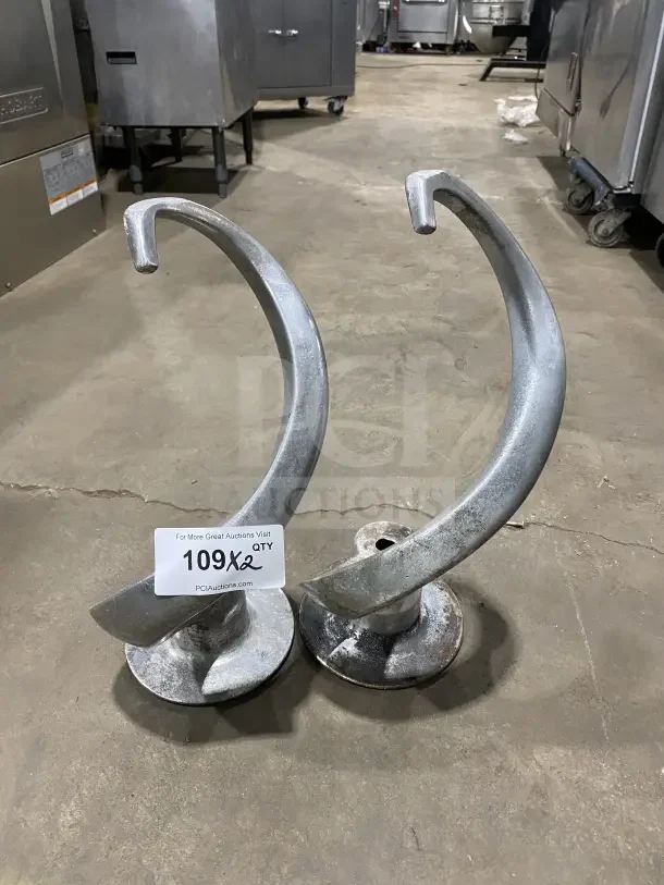 Commercial stainless steel spiral dough hooks for 60Qt planetary mixers, shown in auction setting, used condition.