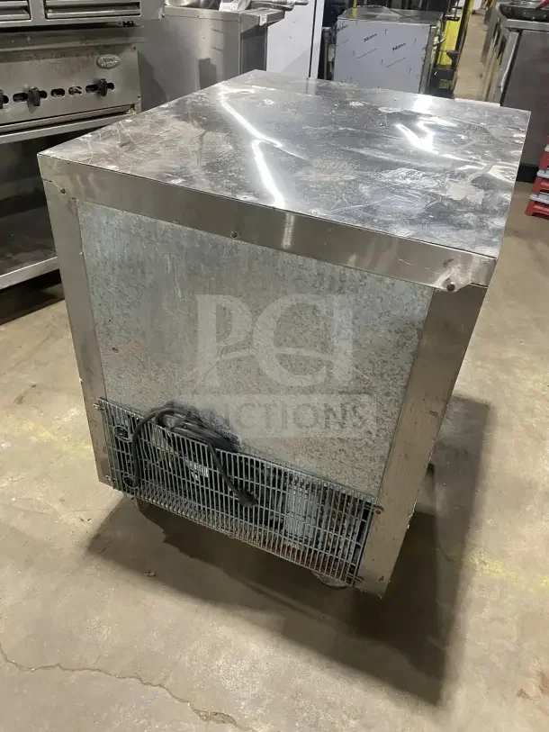 Leader stainless steel single-door undercounter refrigerator, featuring a poly coated wire rack, mounted on casters.
