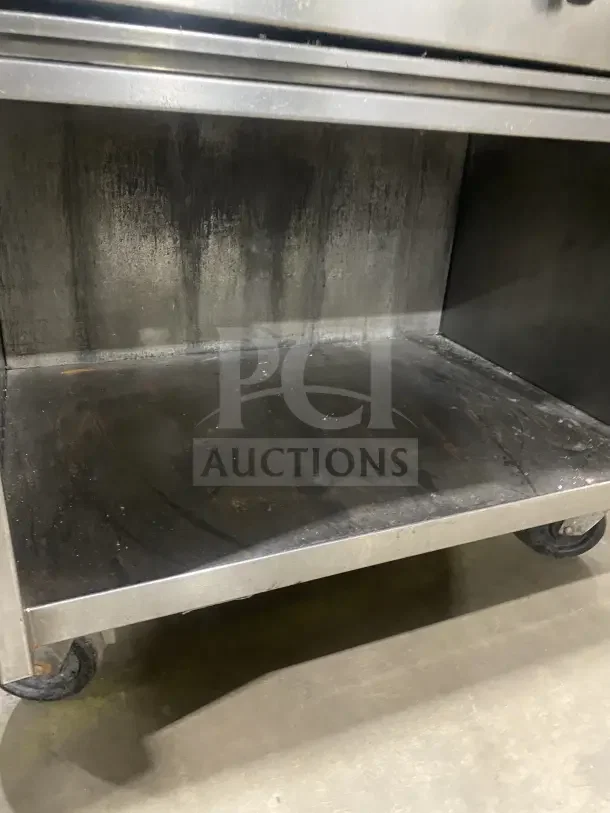 Jade Bistro stainless steel gas-powered charbroiler with open cabinet base, on casters. Features signs of use.