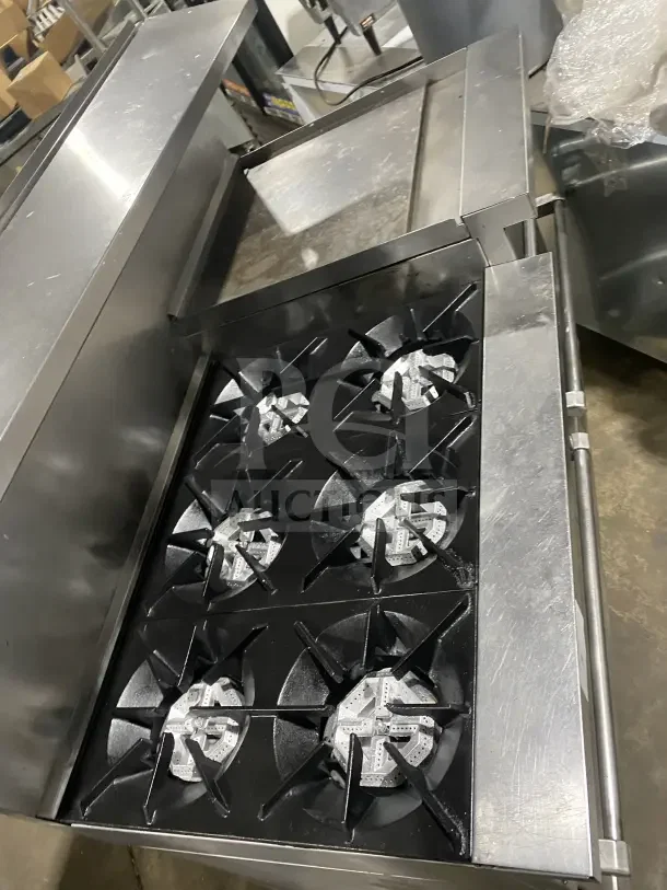 Sunfire Commercial Stainless Steel Gas Range with 6 Burners, side griddle, 2 ovens, wire rack, and casters. In good condition.