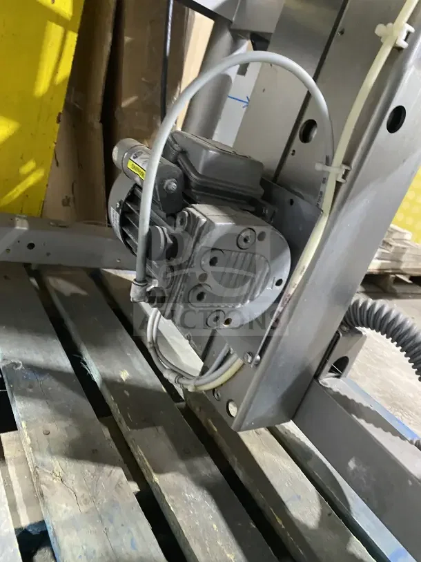 Bizerba commercial stainless steel weigh price labeling machine with digital push controls, mounted on legs, shown in a warehouse.