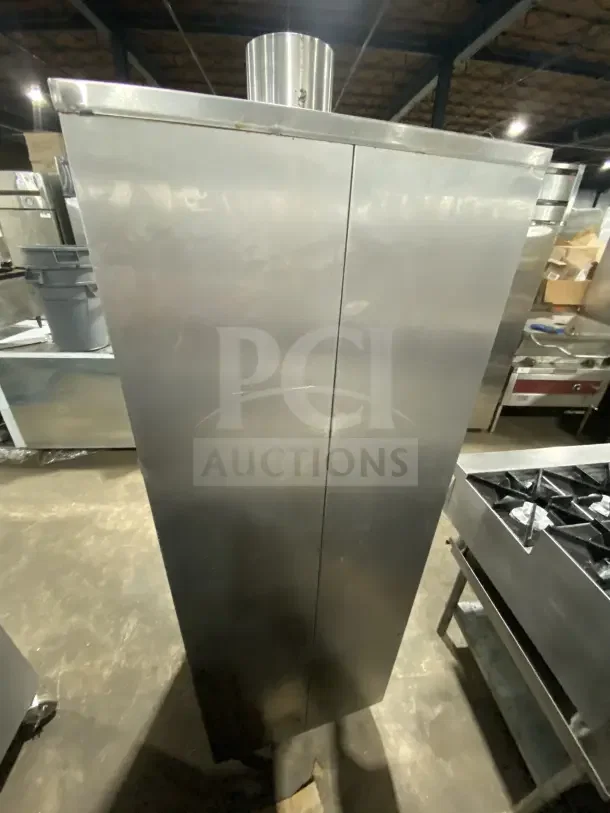 Commercial stainless steel vertical gas-powered smokehouse oven with casters, in good condition. Perfect for BBQ meat smoking.