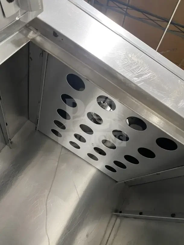 Commercial stainless steel vertical gas-powered smokehouse oven with interior vent holes, on casters, used condition.