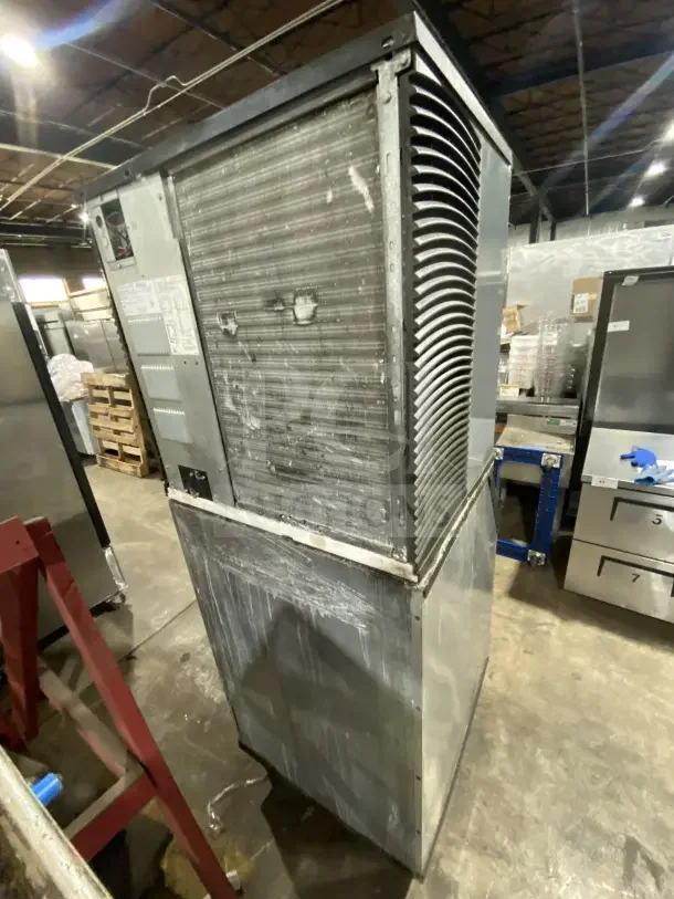 Manitowoc IY1106A-261 stainless steel ice maker, air-cooled, electric 208-230V, 1-phase, on legs, model and serial labels visible.