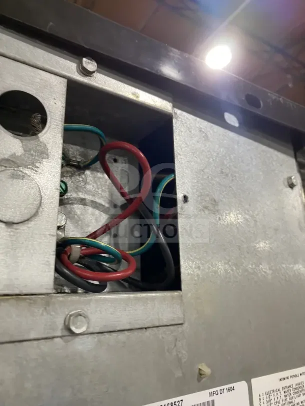 Manitowoc ice machine wiring compartment, model IY1106A-261, showing internal wires and metal casing. Serial number visible.