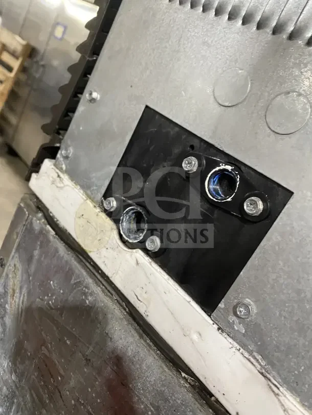 Close-up of the Manitowoc IY1106A261 ice machine's stainless steel exterior, showing mounting details and part of the control panel.