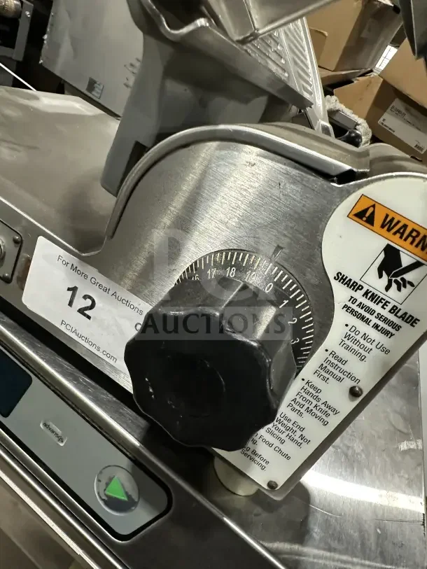 Chefmate Globe Series stainless steel electric deli meat slicer, features manual gravity feed. Visible safety warning label.