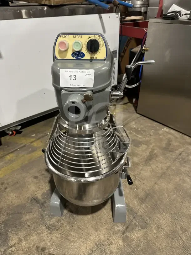 Globe commercial countertop heavy-duty planetary mixer with stainless steel bowl and guard. Features start/stop buttons and timer.
