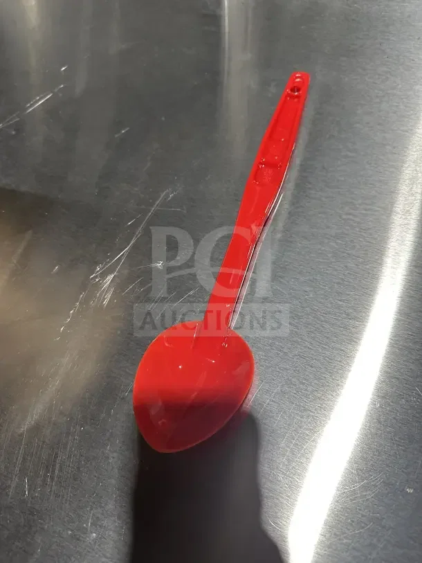 Brand new Camwear 13" red plastic spoon, model SPO13CW404, on a metallic surface.
