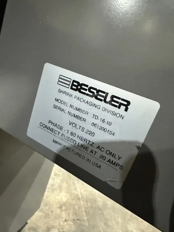 Beseler TD1610 shrink wrap system label, model number TD1610, serial number 061300154, 220V, 1 phase, on casters.