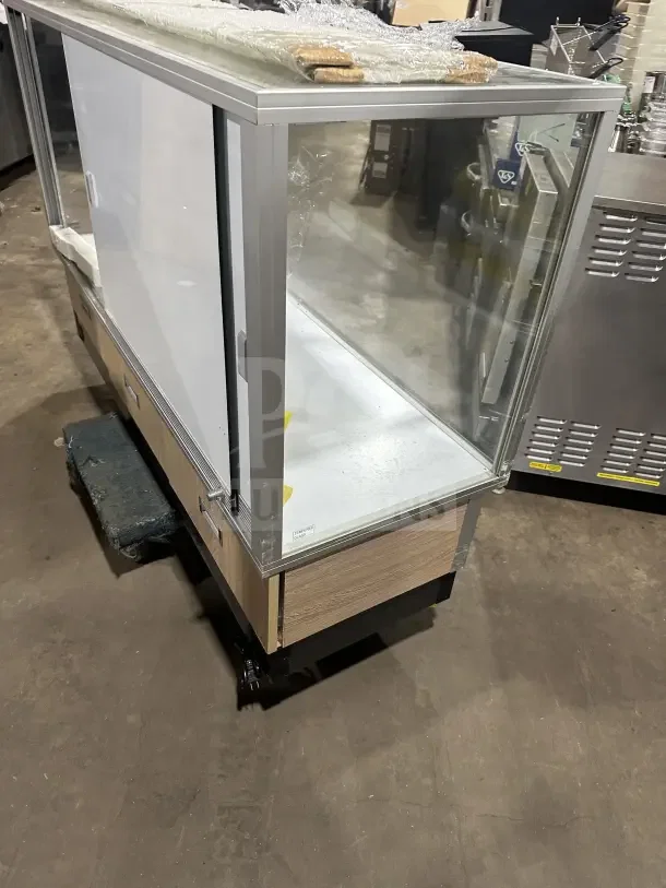 Commercial Extra-Vision retail glass display case with wood base accent. Features sliding doors, excellent condition.