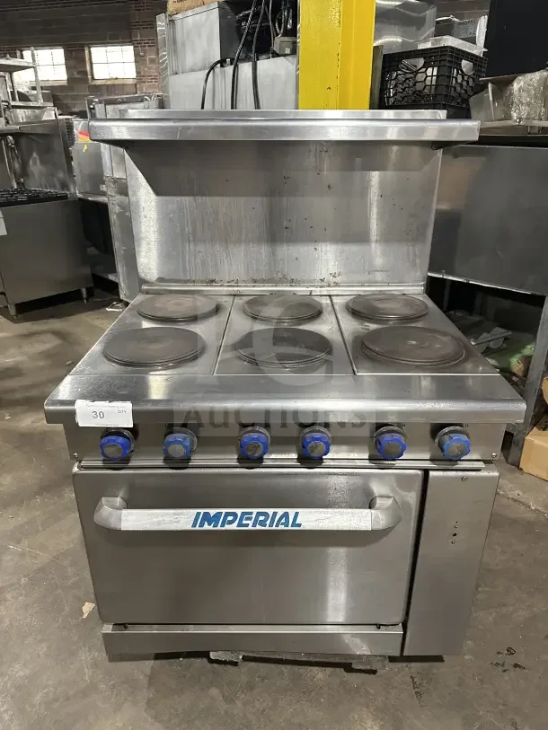 Imperial stainless steel electric 6-burner hot plate range/oven combo with backsplash, salamander shelf, and wired oven rack.