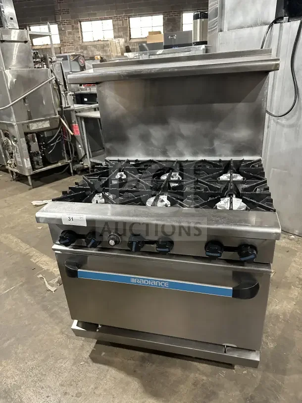 Radiance stainless steel 6-burner gas range with standard oven, backsplash, overhead salamander shelf, and wire rack.