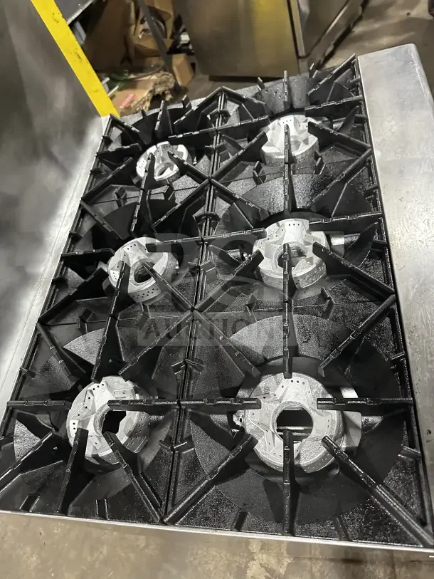 Radiance commercial stainless steel 6-burner gas range with oven, backsplash, overhead salamander shelf, and wire rack.
