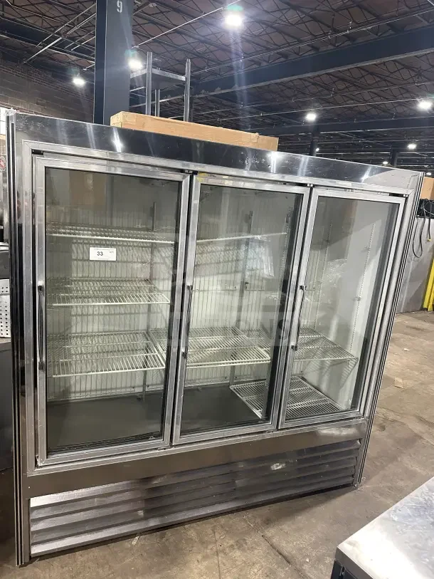 Commercial stainless steel 3-door sliding reach-in refrigerator merchandiser with glass doors and poly coated wire racks.