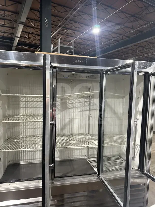 Commercial stainless steel 3-door sliding reach-in refrigerator merchandiser with poly-coated wire racks, excellent condition.