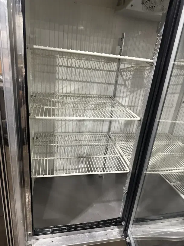 Commercial 3-door sliding reach-in refrigerator with poly-coated wire racks, stainless steel, glass doors, excellent condition.