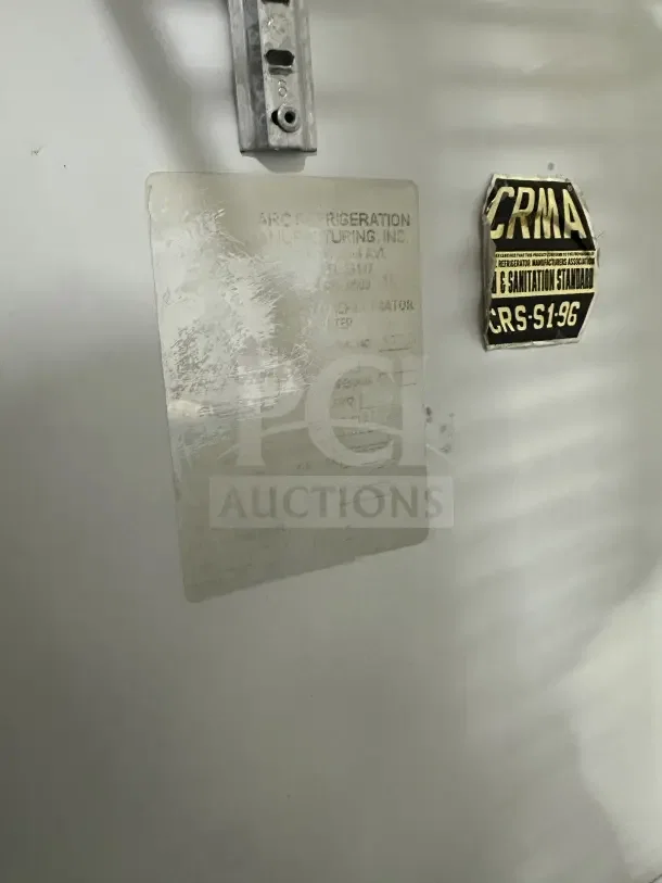 Commercial stainless steel 3-door sliding reach-in refrigerator with poly coated wire rack. CRMA safety label visible.