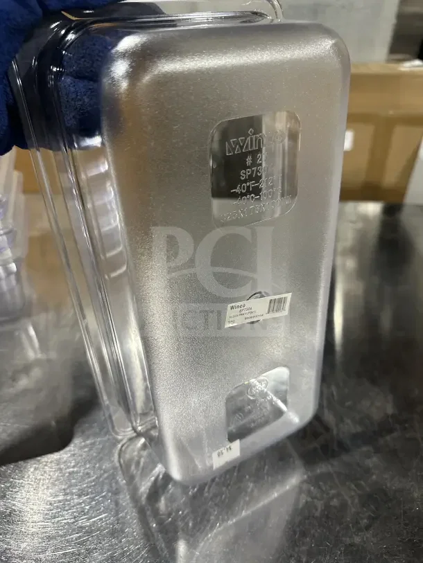 Winco SP7304 clear polycarbonate 1/6-size food pan, commercial-grade, with embossed temperature range and item labels visible.