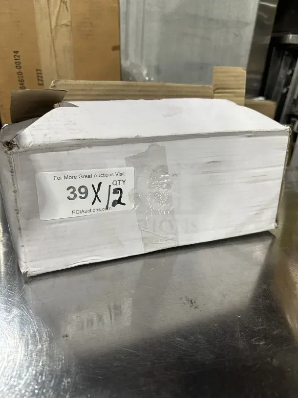 Box containing a brand new commercial 2 oz stainless steel solid portion control spoon, red handle, labeled "39X/QTY 12."