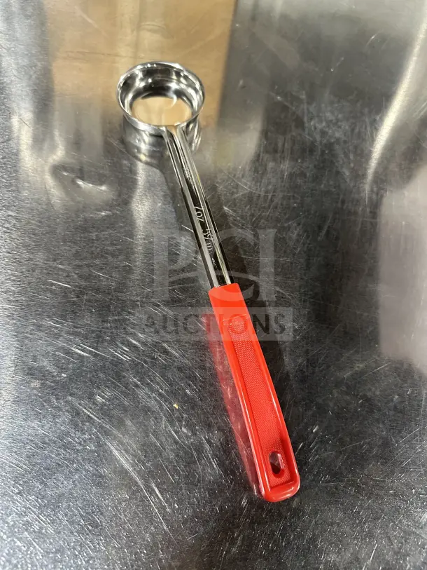 Brand new 2 oz stainless steel red control spoon, solid portion, with red plastic handle, visible measurement markings.