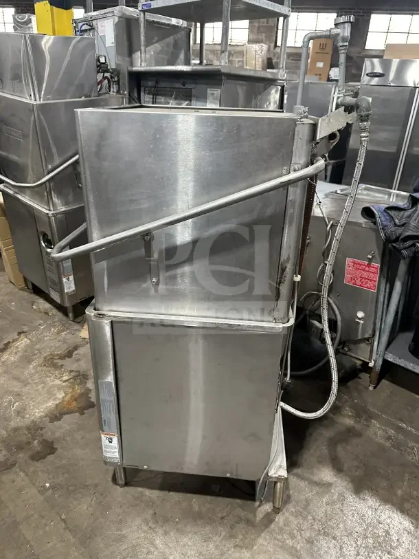 Hobart AM15 commercial stainless steel dishwashing machine, ventless design, electric powered, on legs, visible hookups.