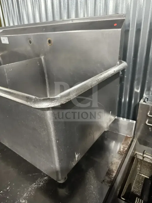 Commercial stainless steel 2-compartment sink with legs, utility style, scullery sink, visible wear, metal backdrop.