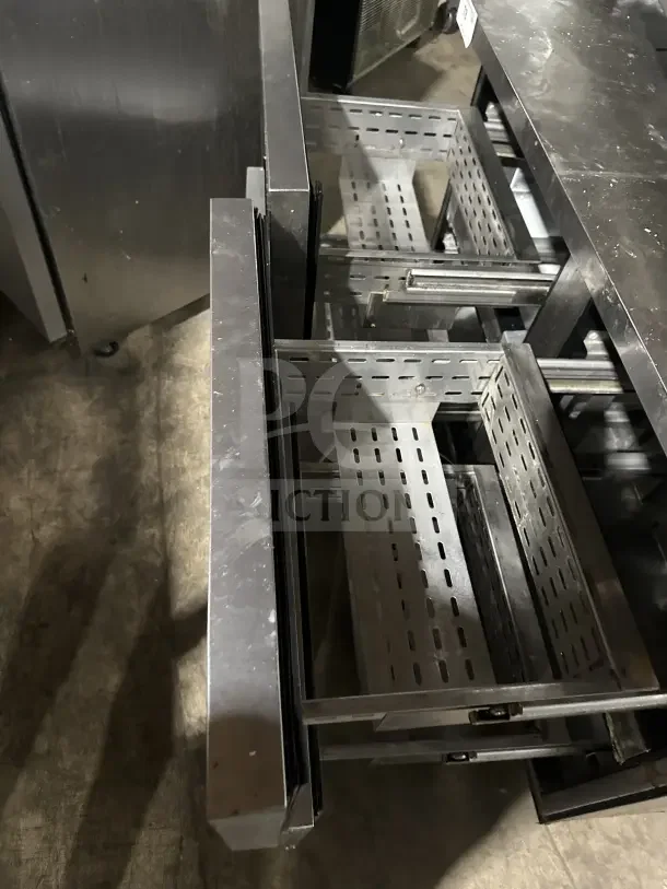 True TWT-48D-4 stainless steel worktop table/undercounter refrigerator, featuring 4 drawers, backsplash, and casters.