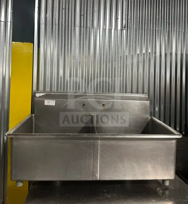 Commercial stainless steel 2-compartment utility sink with legs, intact and sturdy. Features backsplash with faucet holes.