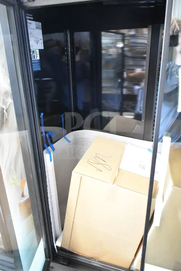 Brand new True TVM-48SL-HC 2-door reach-in cooler, 115V, showing interior packaging. Tags indicate model and specs.