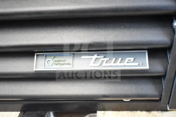 "True TVM-48SL-HC commercial cooler branding, featuring 'natural refrigerant' label on black surface."
