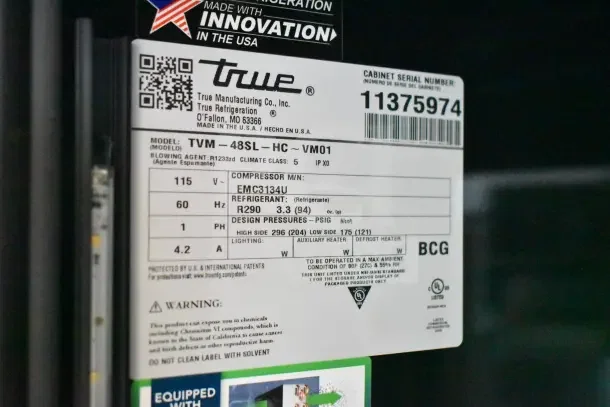 Label on True TVM-48SL-HC cooler shows model details, 115V, 60Hz, R290 refrigerant. Serial number 11375974, made in USA.