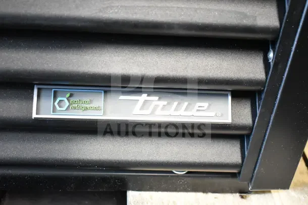 Brand new 2026 True TVM-48SL-HC commercial cooler logo, featuring natural refrigerant marking on black louvered panel.